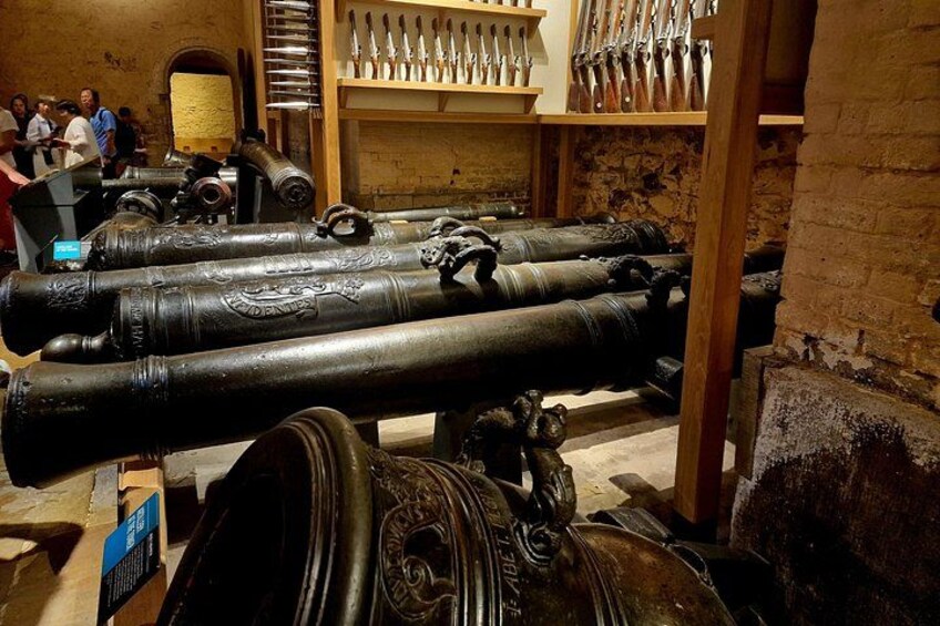 Una exposición de museo con cañones grandes y armas históricas. 3