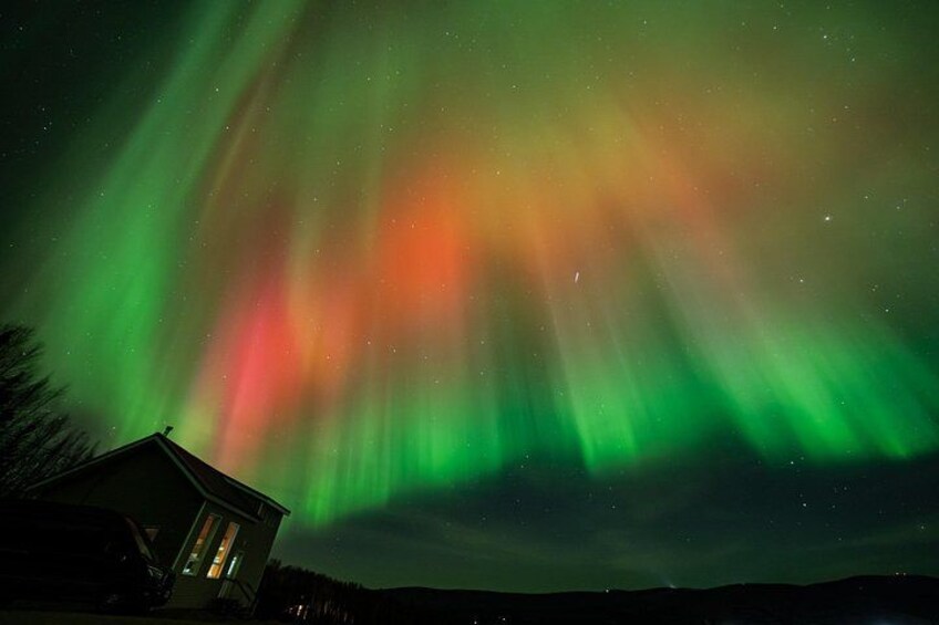 The Northern Lights over a house at night. 3