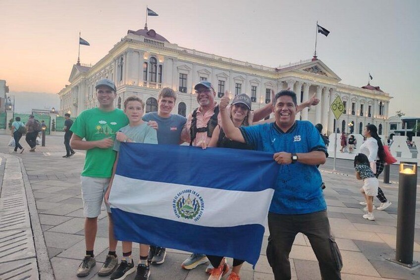 A group of people holding a flag in front of a building with classical architecture. 3