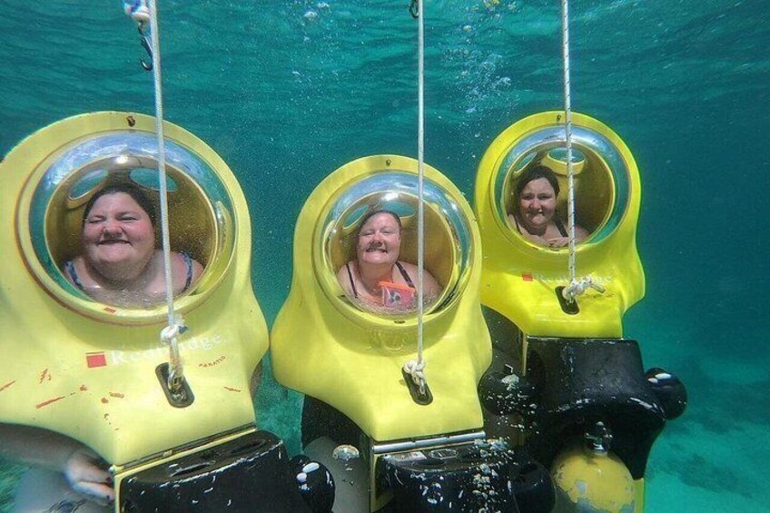 Three people in yellow diving helmets underwater. 3