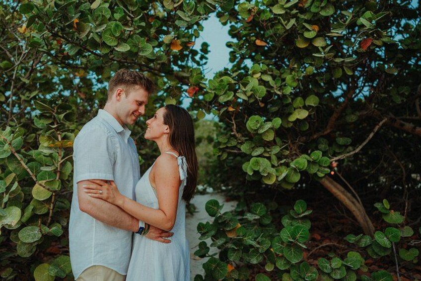 A couple embracing in a lush green setting with dense foliage. 5