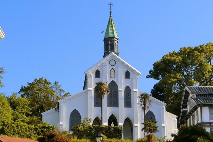 A white church with a green spire and arched windows. 3
