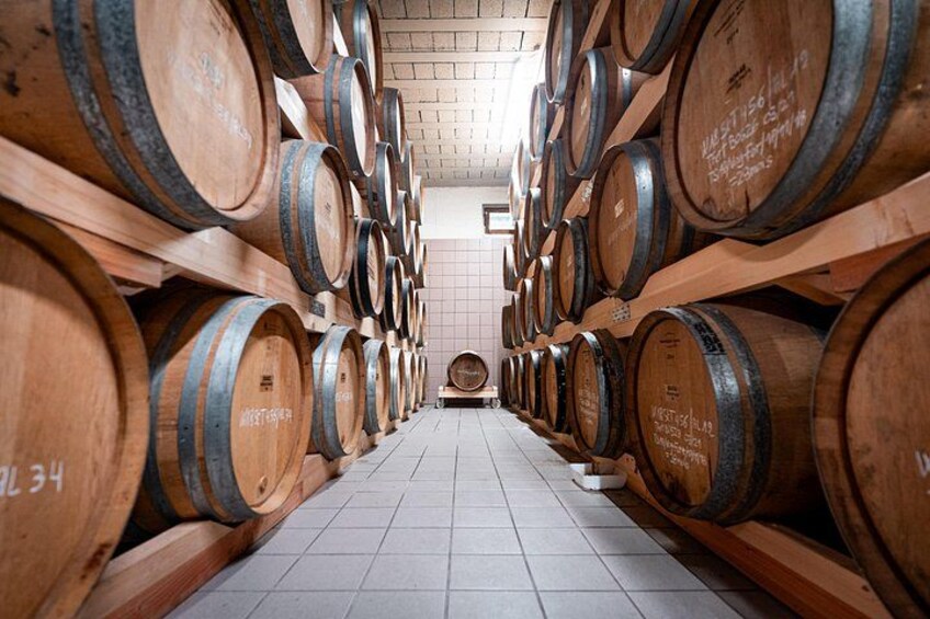A wine cellar with rows of wooden barrels. 3