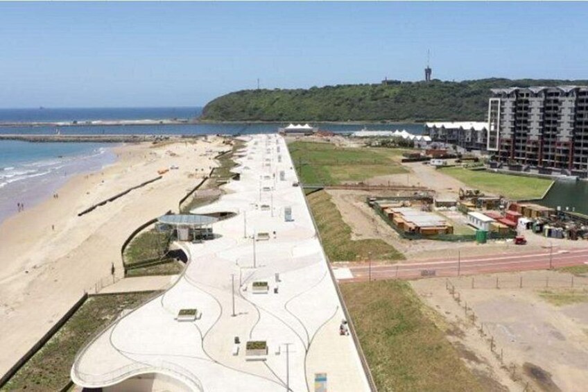 Eine Uferpromenade mit Strand, Fußgängerweg und einer Baustelle. 4