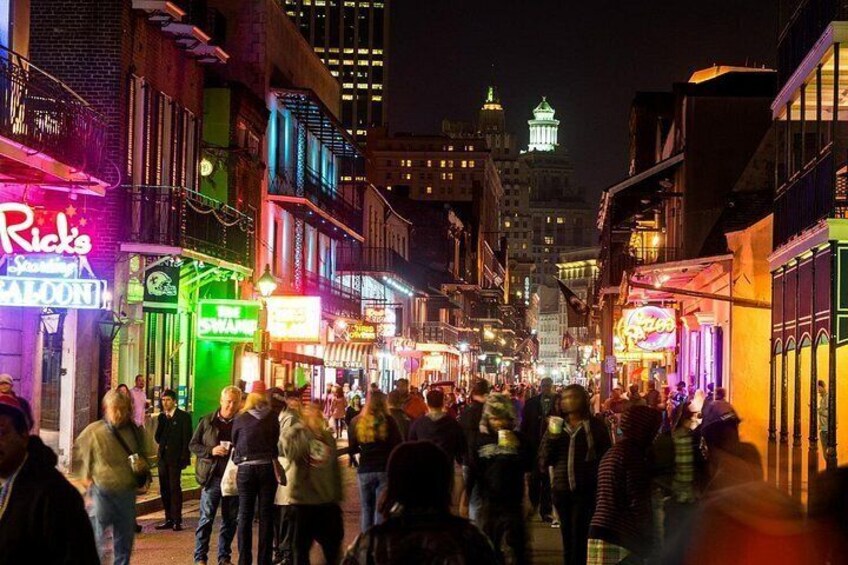 Una calle concurrida de noche, con letreros y edificios iluminados. 4