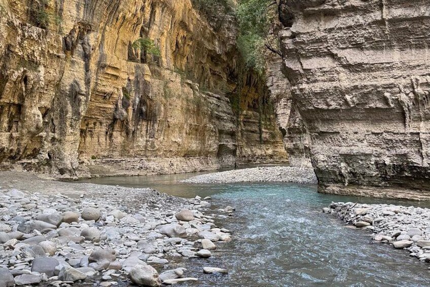 A river flowing through a canyon with rocky terrain and layered rock formations. 2