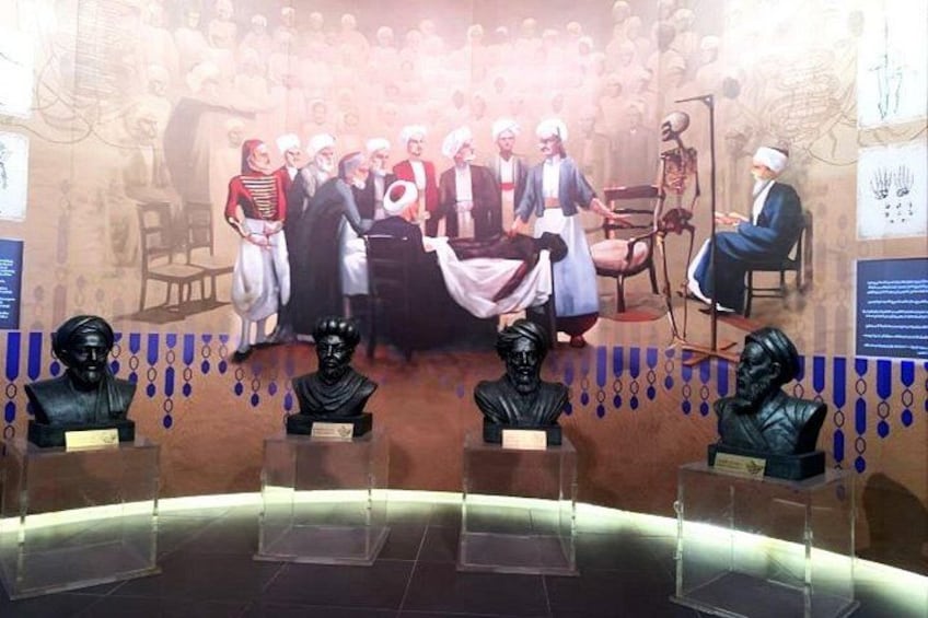 Una exposición de museo con bustos y una pintura histórica. 5