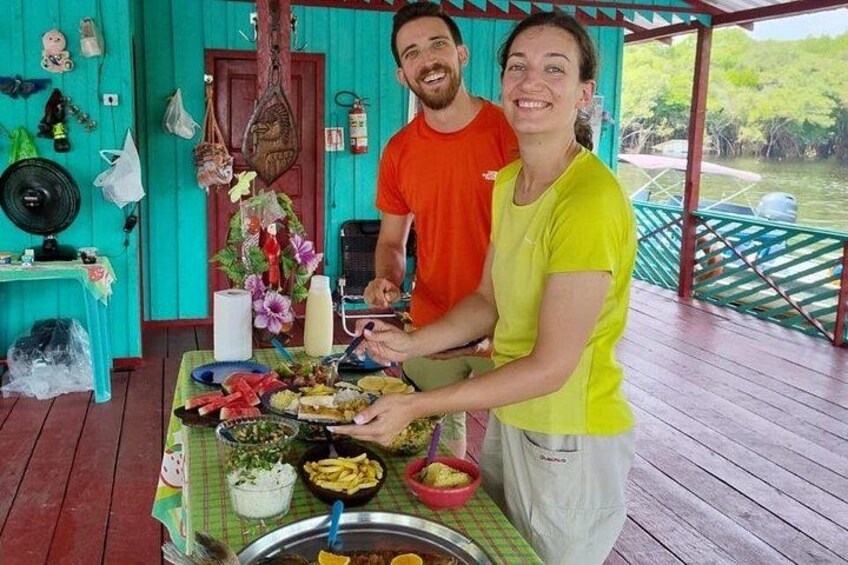 A wooden deck with a table set for a meal, surrounded by greenery. 2
