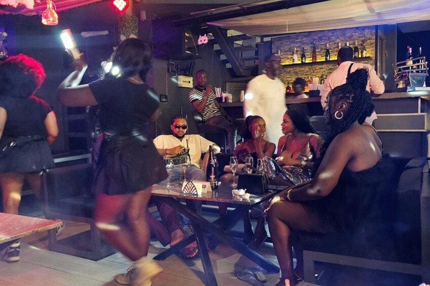 Un grupo de personas sentadas en una mesa en un bar o restaurante. 2