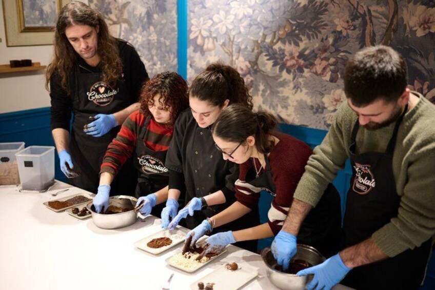Personen met schorten en handschoenen bereiden eten op een tafel. 5