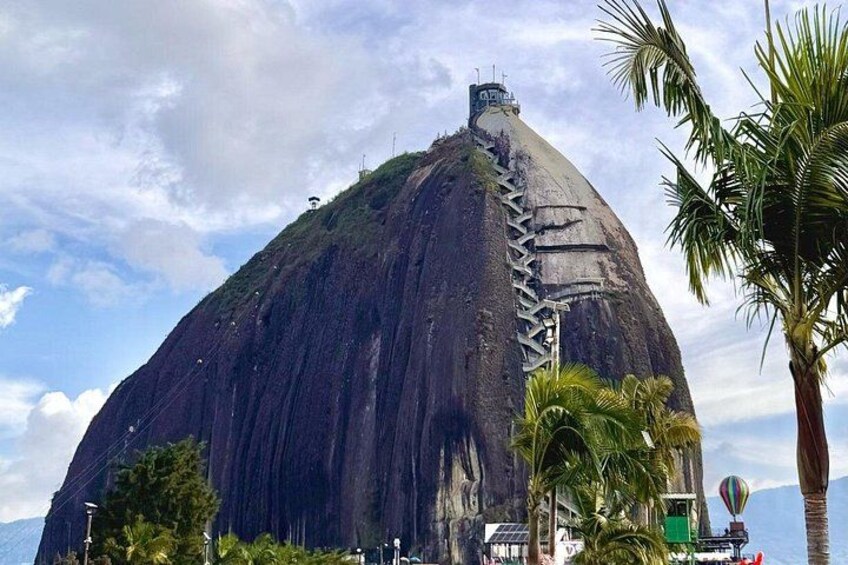 A large, steep rock formation with a staircase leading to the top. 3