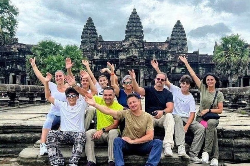 A group of people posing in front of a large, ancient temple with multiple towers. 3