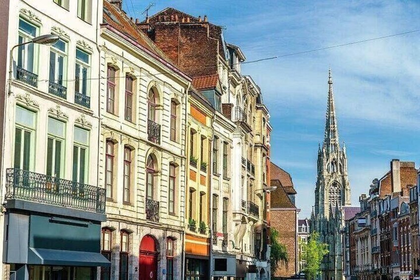 A street with historic buildings and a church spire. 2