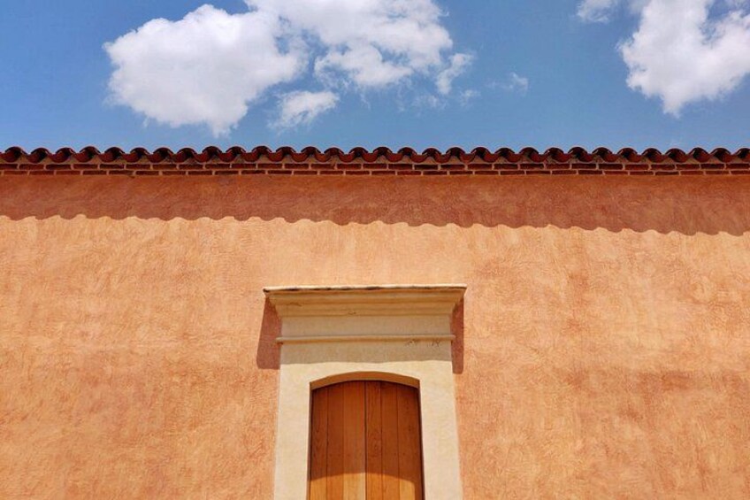 A building with a terracotta facade and a tiled roof. 2