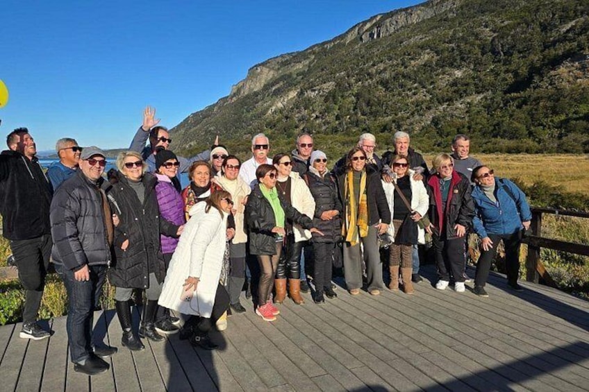 A group of people on a wooden deck with a mountainous landscape in the background. 4