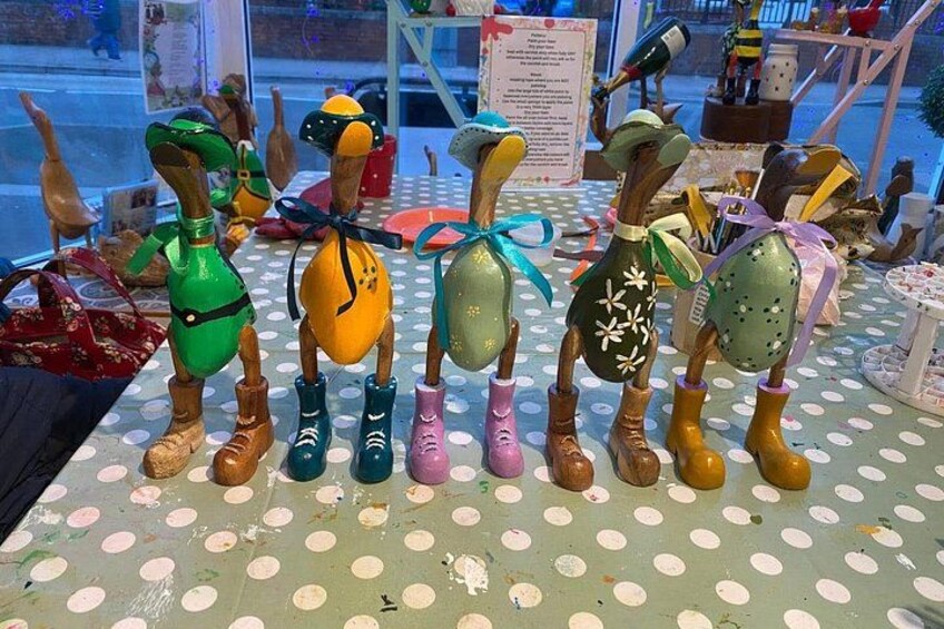 A display of colorful wooden figures with boots and ribbons. 3