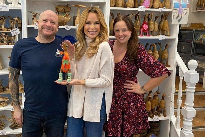 Three people in a store with shelves of animal figurines. 1