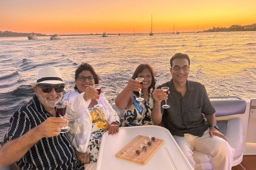 Un grupo de personas en un barco, con un atardecer de fondo. 1