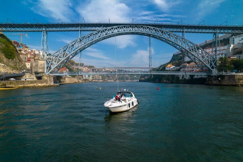 Una barca su un fiume sotto un grande ponte, con edifici sullo sfondo. 5