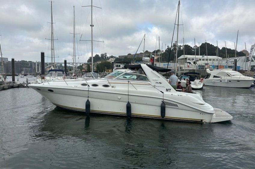 Een witte jacht afgemeerd in een jachthaven, met andere boten op de achtergrond. 4