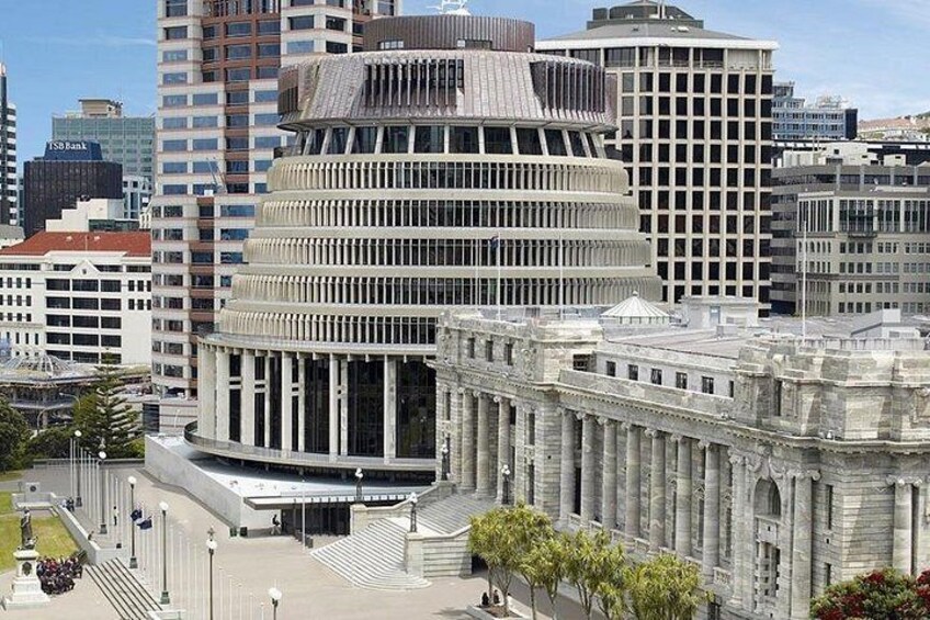 A modern building with a curved facade, surrounded by other high-rise buildings and a classical structure with columns. 2