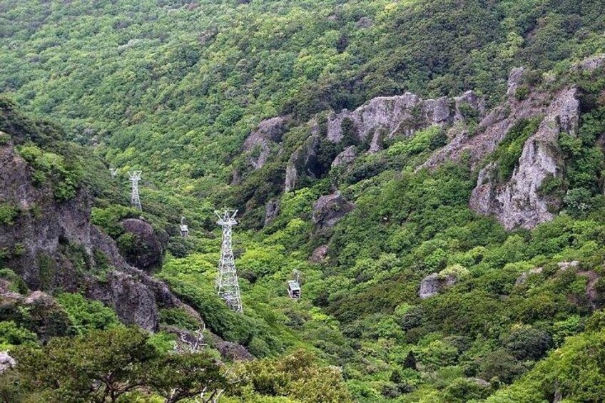 Bjergrigt landskab med frodig vegetation og flere sendemaster. 2