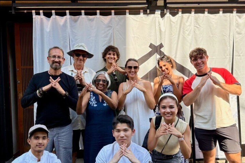 A group of people posing in front of a white curtain with a cross symbol. 2
