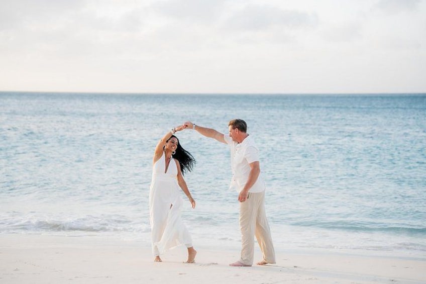 A couple on a beach with the ocean in the background. 3