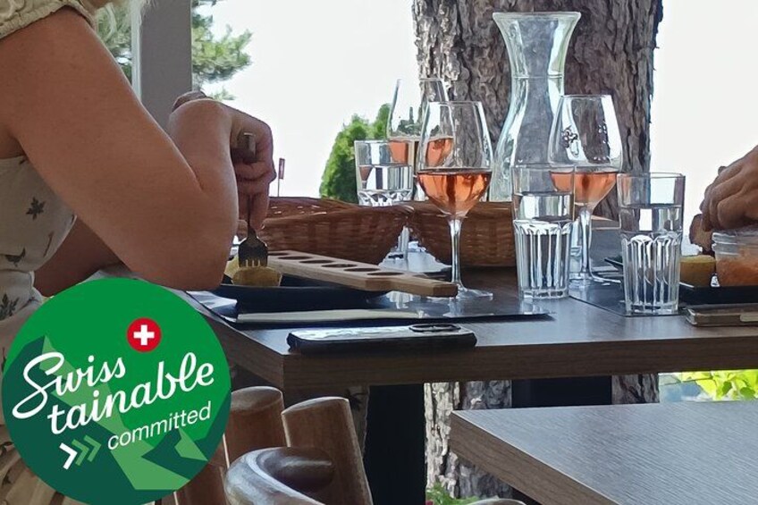 A person dining outdoors with a table set with wine glasses and a basket. 1