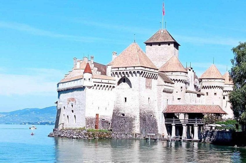 Eine Burg an einem See mit mehreren Türmen und einer Flagge. 2