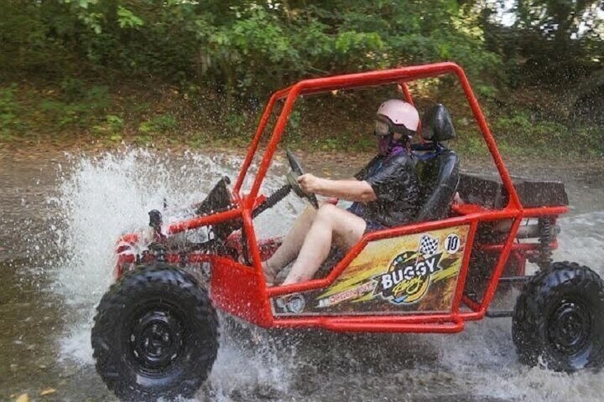 Una persona conduce un buggy rojo por el agua. 1