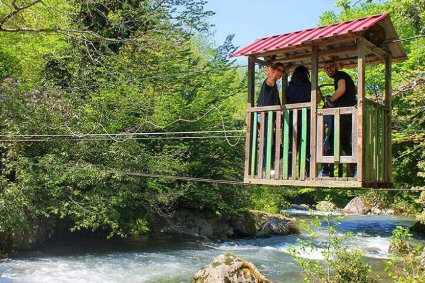 A wooden observation tower over a river surrounded by greenery. 3