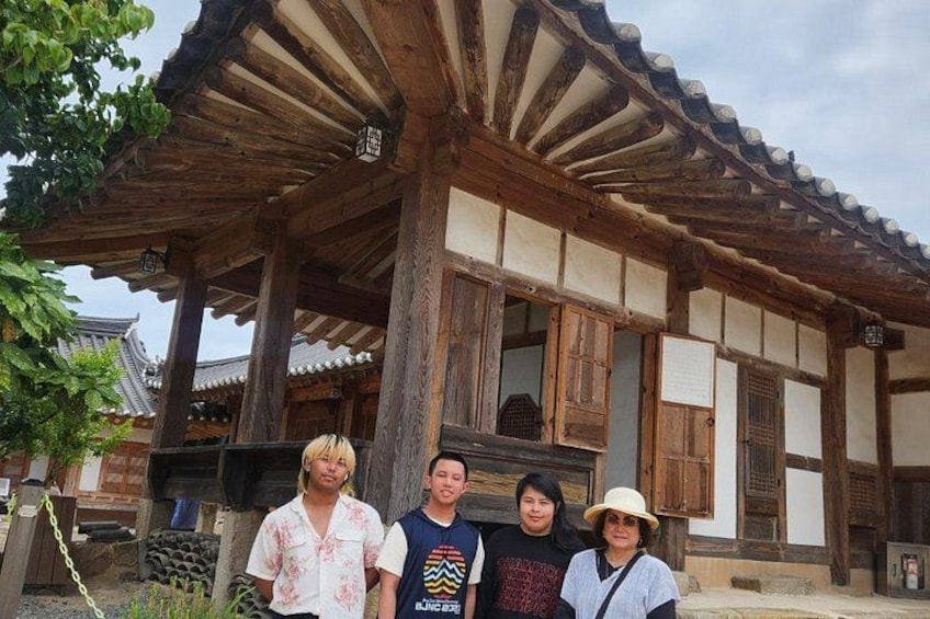 A traditional wooden building with a tiled roof, wooden pillars, and a wooden door. 5
