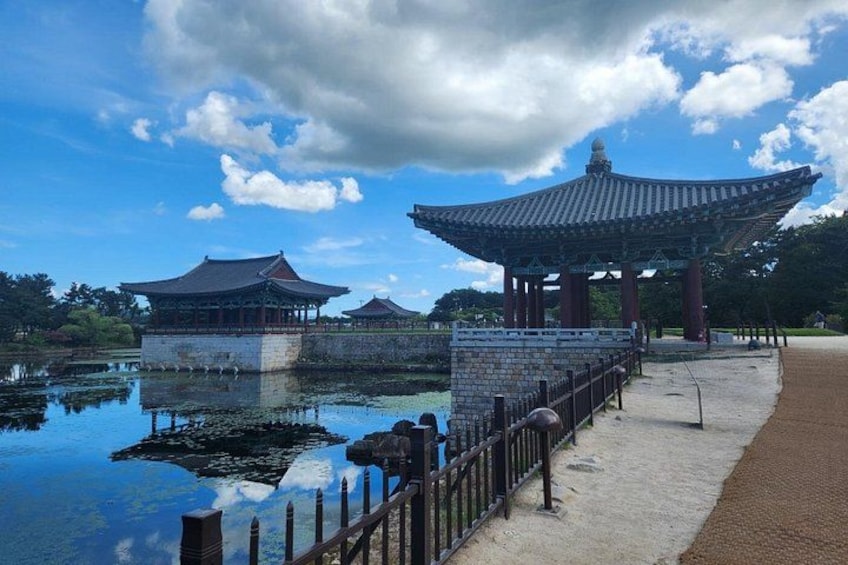 Traditional Korean architecture with a pavilion, a stone bridge, and a pond. 3
