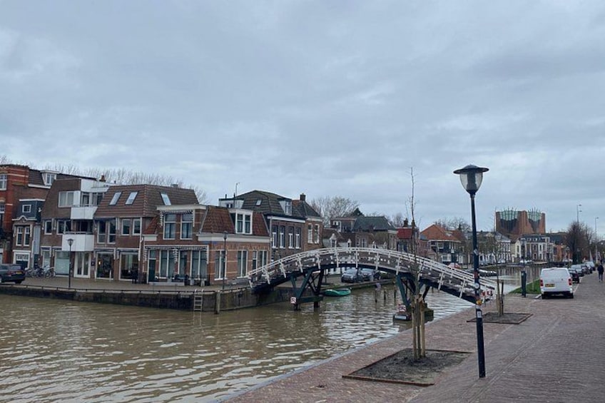 A canal with houses, a bridge, and a street lamp. 4