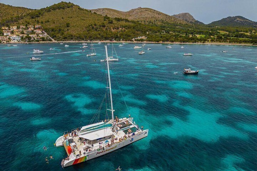 A sailboat on turquoise waters with a mountainous backdrop. 5