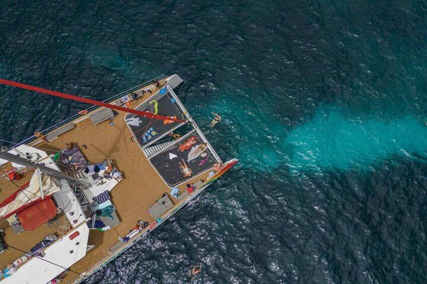 Un bateau avec des personnes à bord, entouré d’une eau turquoise. 3