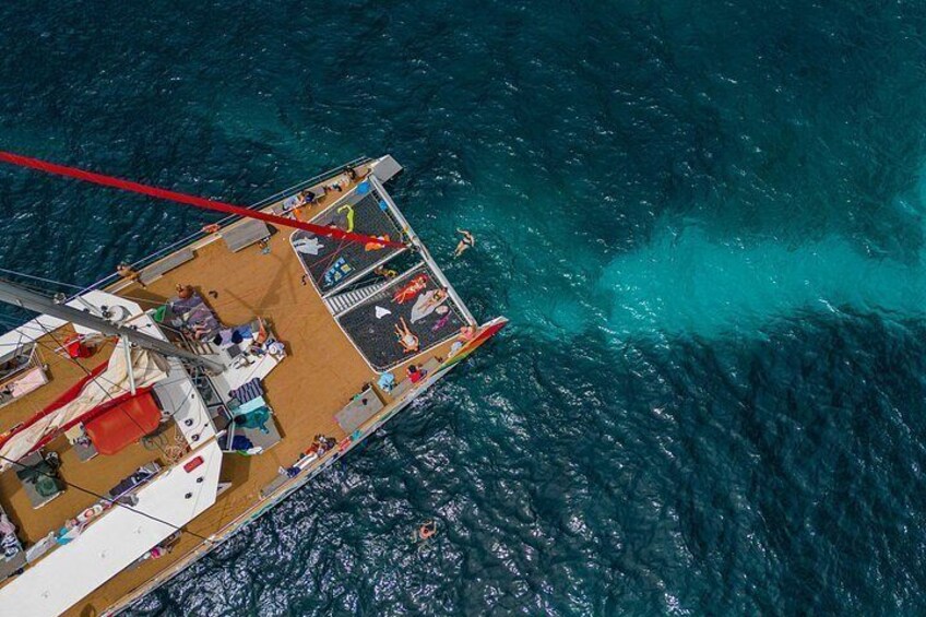 A boat with people on deck, surrounded by turquoise water. 3