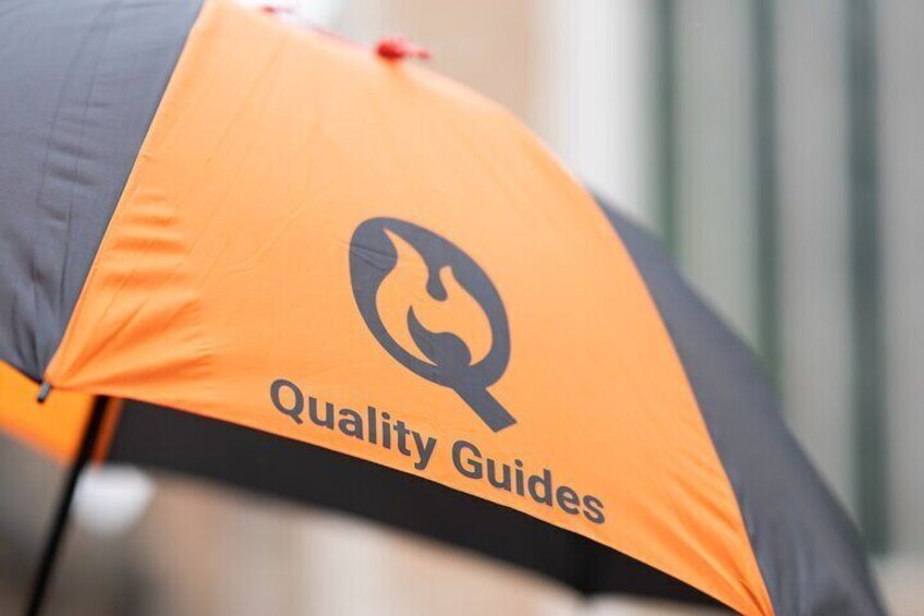 A black and orange umbrella with a flame logo and the text "Quality Guides". 2
