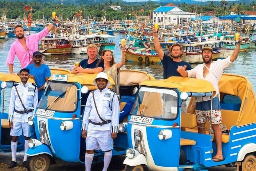 A group of people on a boat, a blue auto-rickshaw, and a busy harbor with multiple boats. 4