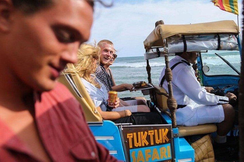 A group of people on a safari vehicle with a sign reading 'TUKTUK SAFARI'. 5