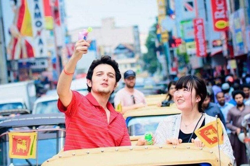 A person in a red shirt holding a drink, another person in a white shirt, and a yellow vehicle with a flag. 5