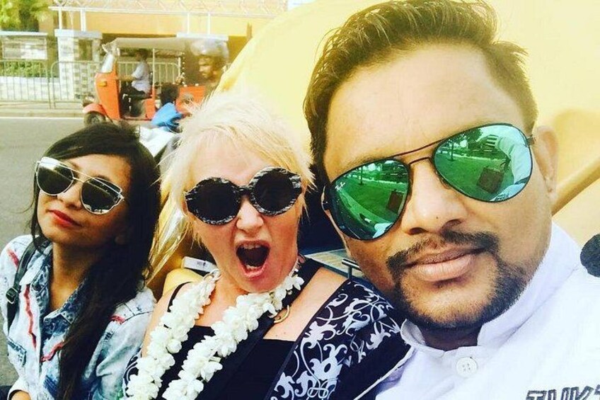 Three people with sunglasses, one wearing a floral lei. 3