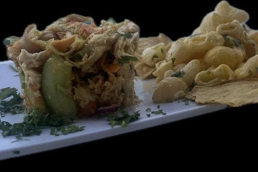 A dish with a creamy filling, a slice of cucumber, and some herbs on a white plate. 5