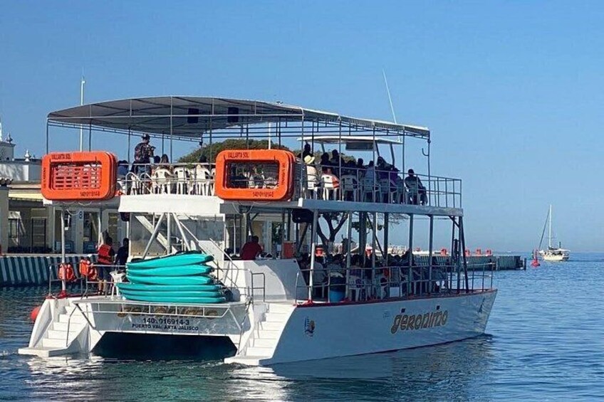 A boat named 'Geroamino' with people on board, docked at a pier with another boat in the background. 2