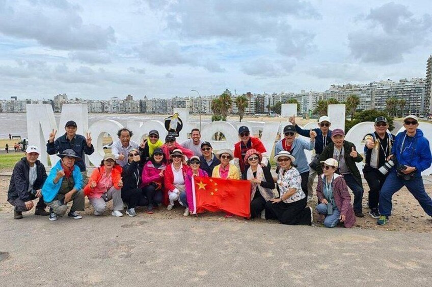 A group of people posing with a flag in an urban setting with buildings in the background. 5