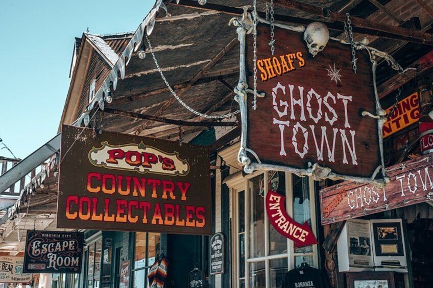 A storefront with signs for 'Pop's Country Collectables' and 'Shof's Ghost Town'. 2