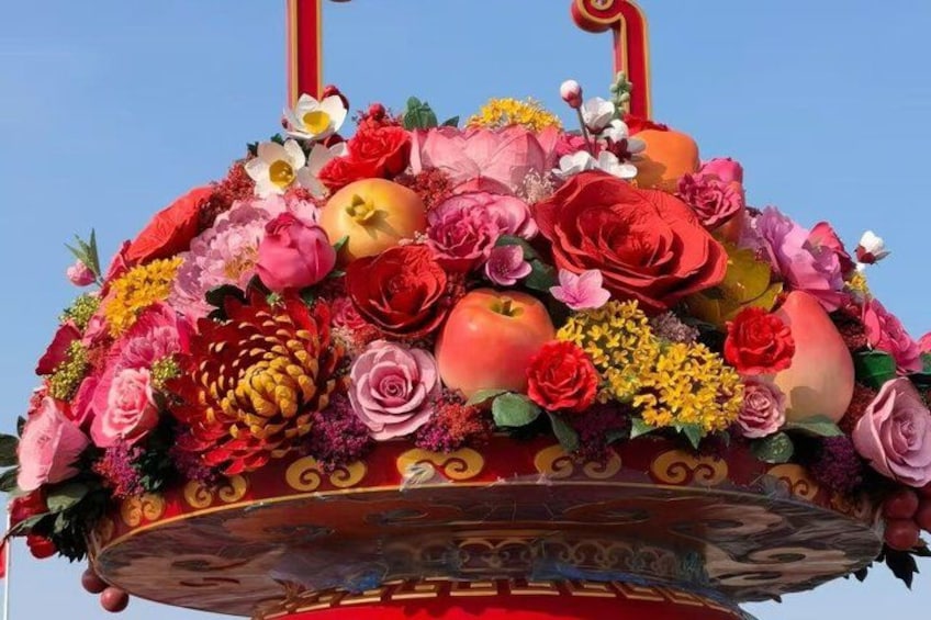 A large, ornate floral arrangement with a red and gold design, featuring a variety of flowers and decorative elements. 2