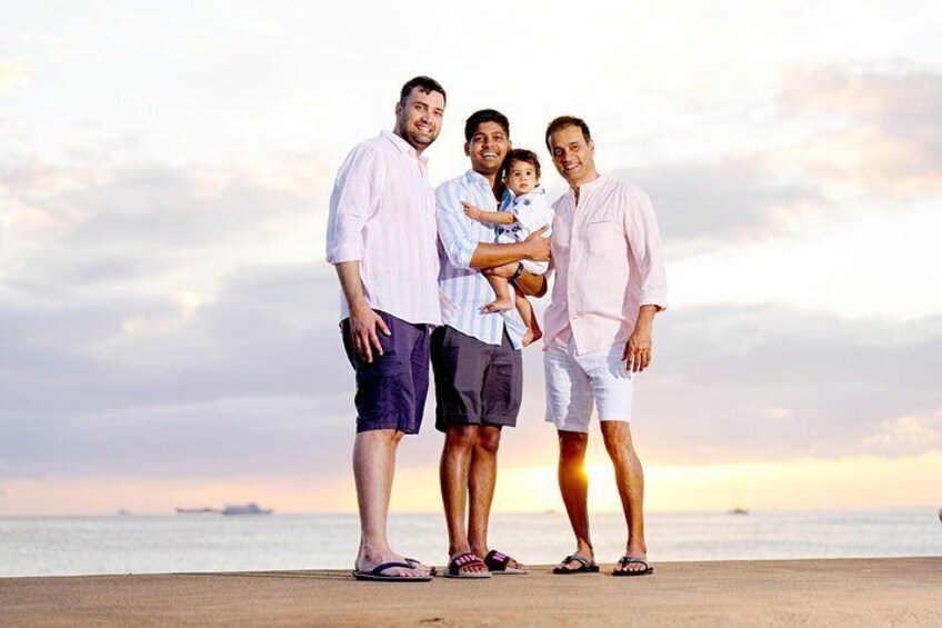 Una familia de cuatro personas de pie en una playa, con un atardecer de fondo. 2