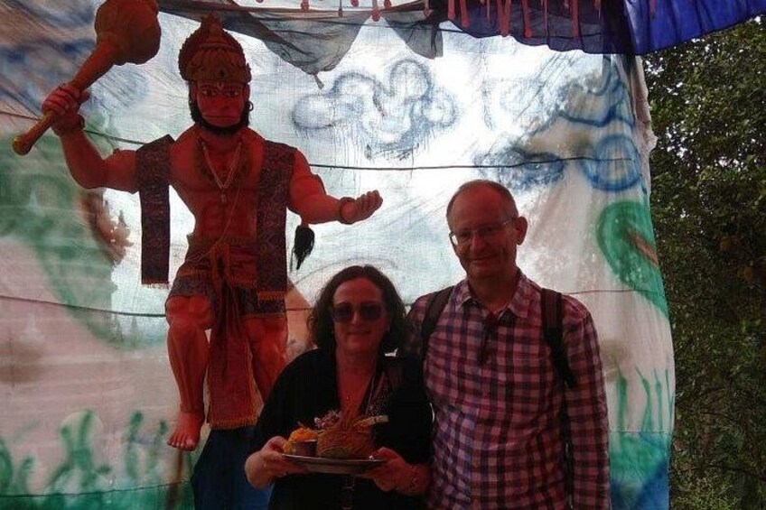 Una persona sosteniendo un plato con comida, un hombre con camisa escocesa y una estatua al fondo. 3